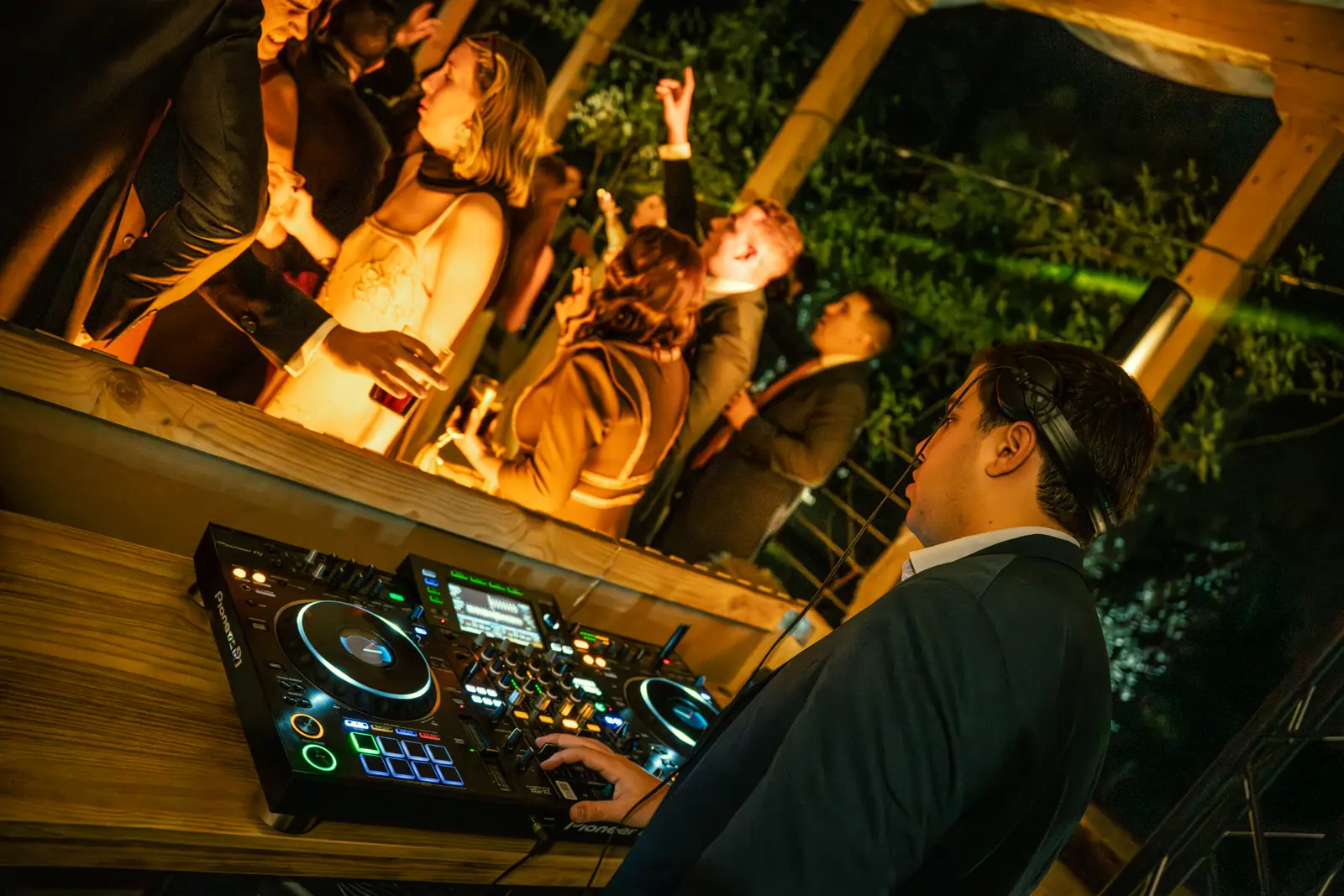 DJ en la consola durante la boda, manejando equipamiento profesional de sonido y luces.