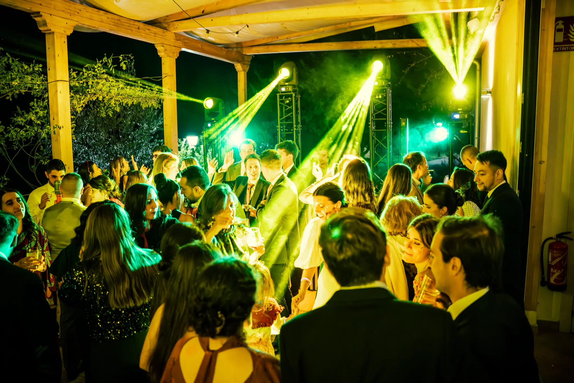 Pista de baile iluminada con láser verde intenso, público bajo la atmósfera creada por La Montada.