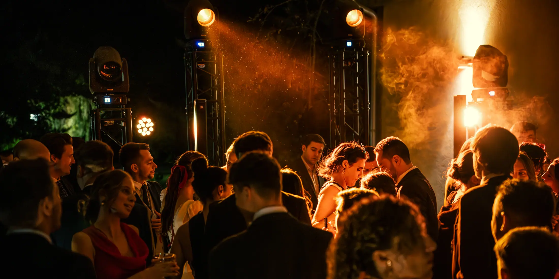 Pista de baile iluminada con luz cálida mientras los invitados celebran bajo el diseño de La Montada.