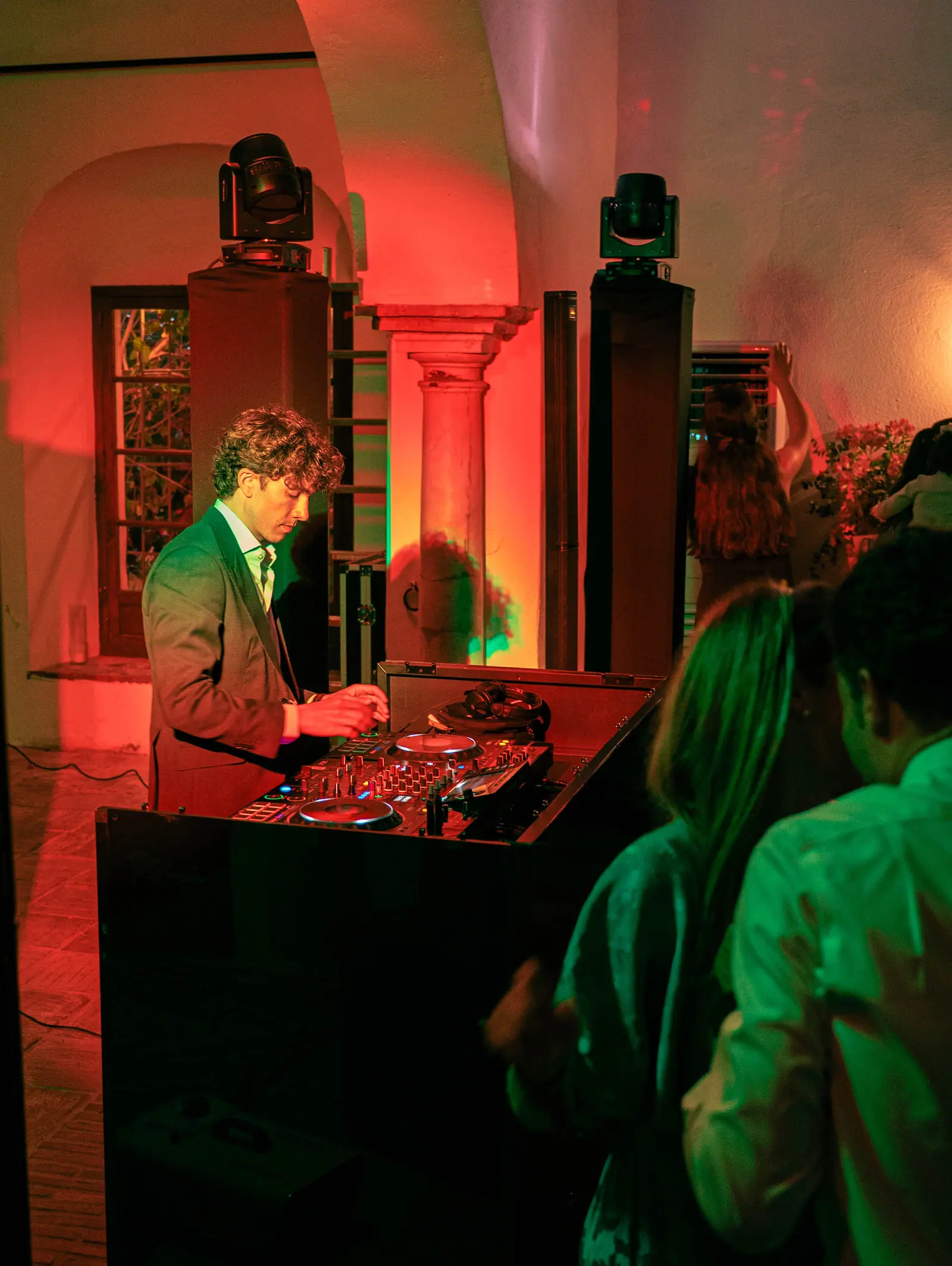 Dos personas bajo iluminación roja y verde con columnas decorativas de ambiente de boda