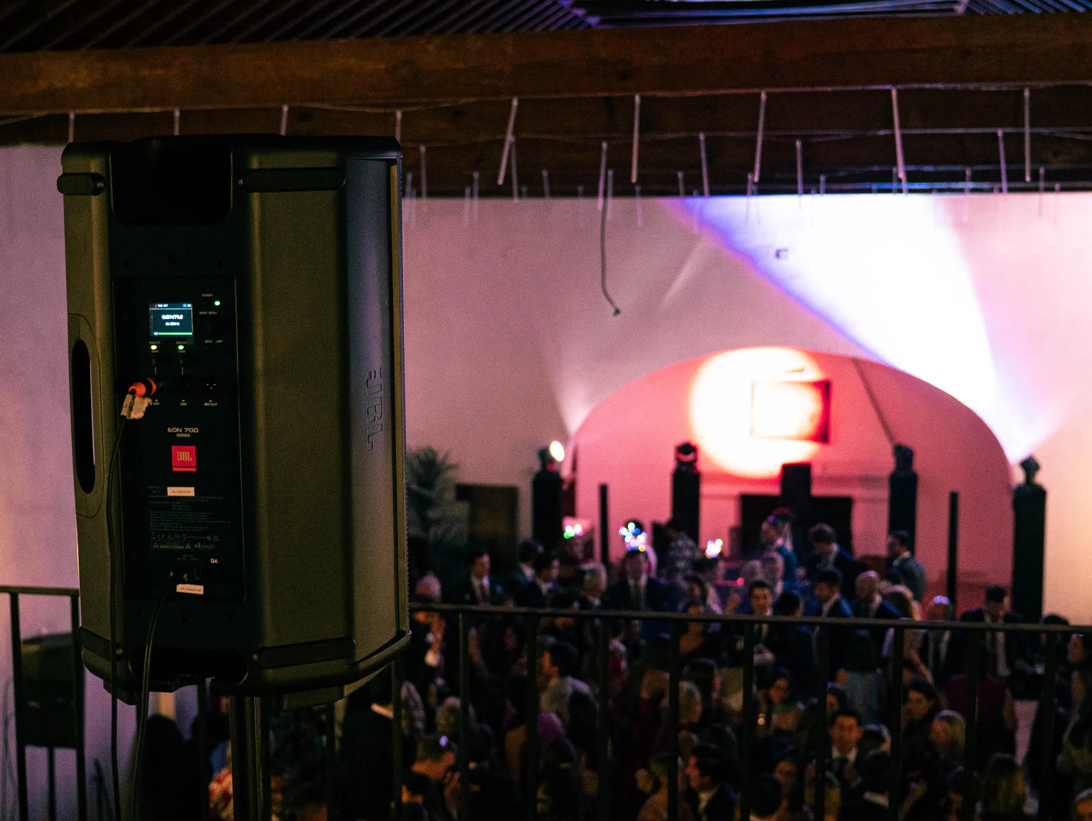 Pista de baile en montaje de boda con iluminación rosada, sonido profesional y arquitectura de arco