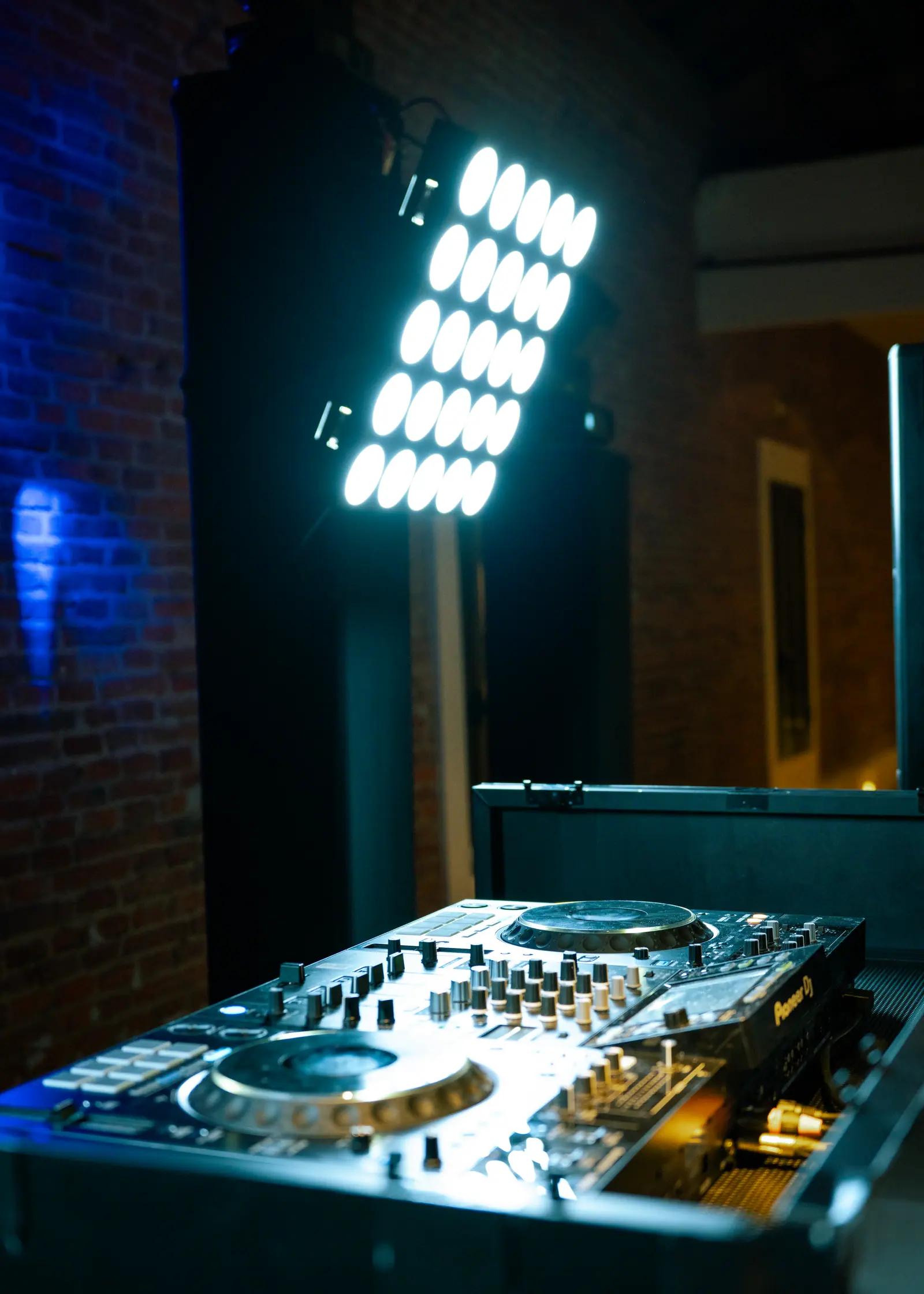 Cabina de DJ iluminada con controlador y equipo de sonido profesional