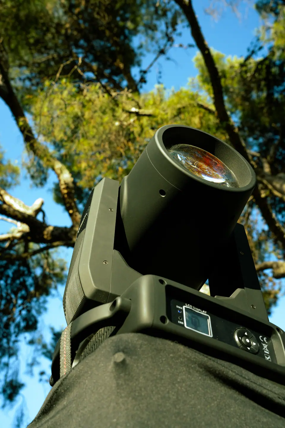 Detalle de proyector de luz montado en árbol, instalación de escena