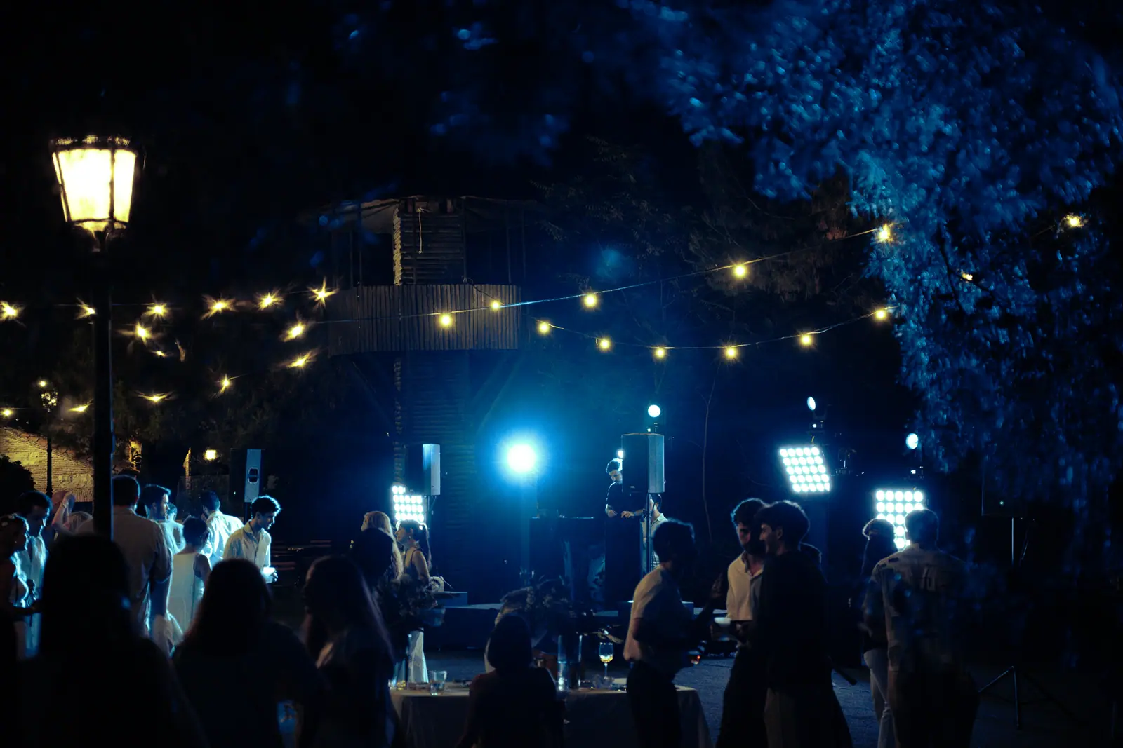 El público bajo la iluminación azul de un evento nocturno