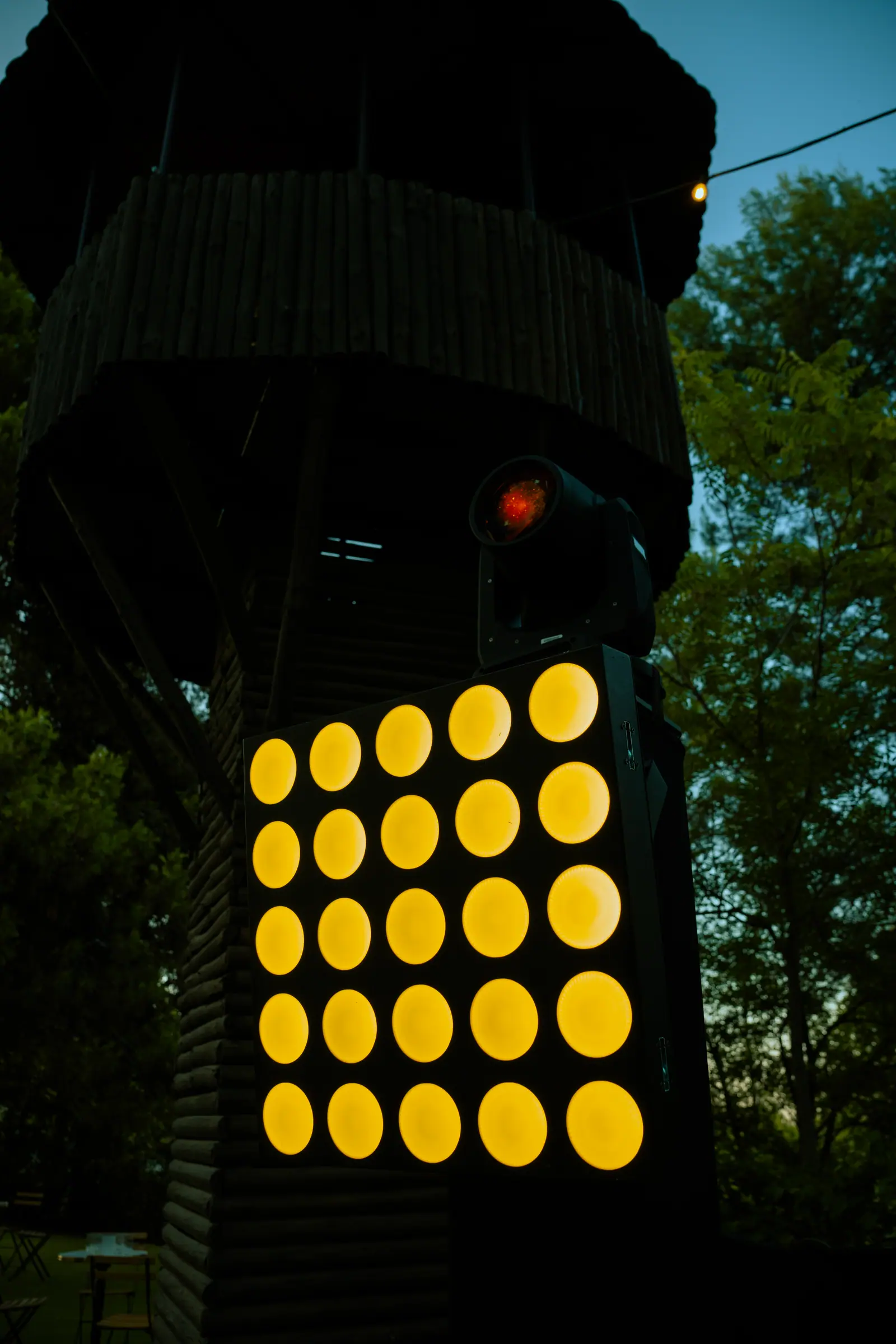 Grid LED dorado entre árboles, iluminación profesional en la finca