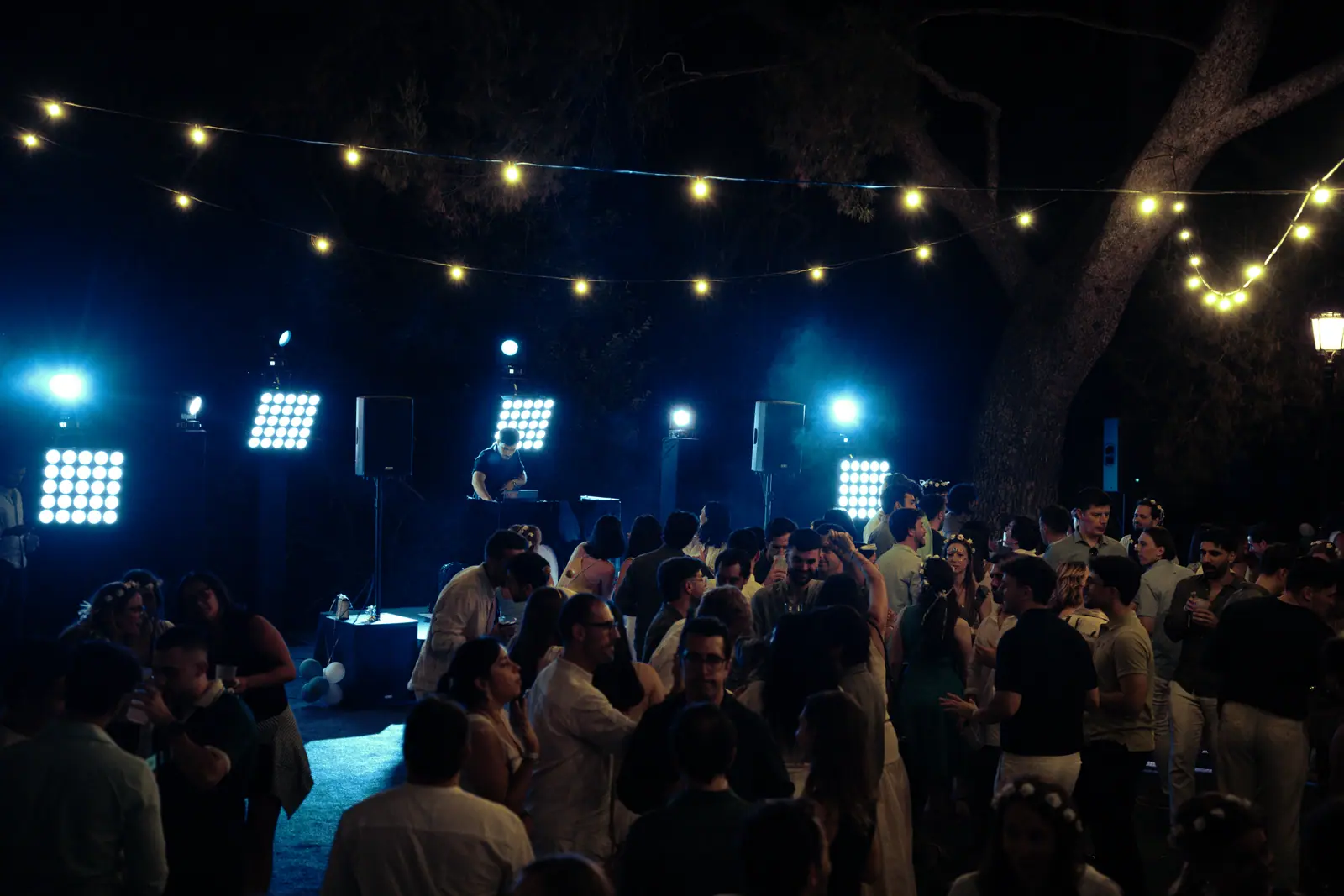 Multitud bajo luces de escena azules, producción nocturna profesional de evento