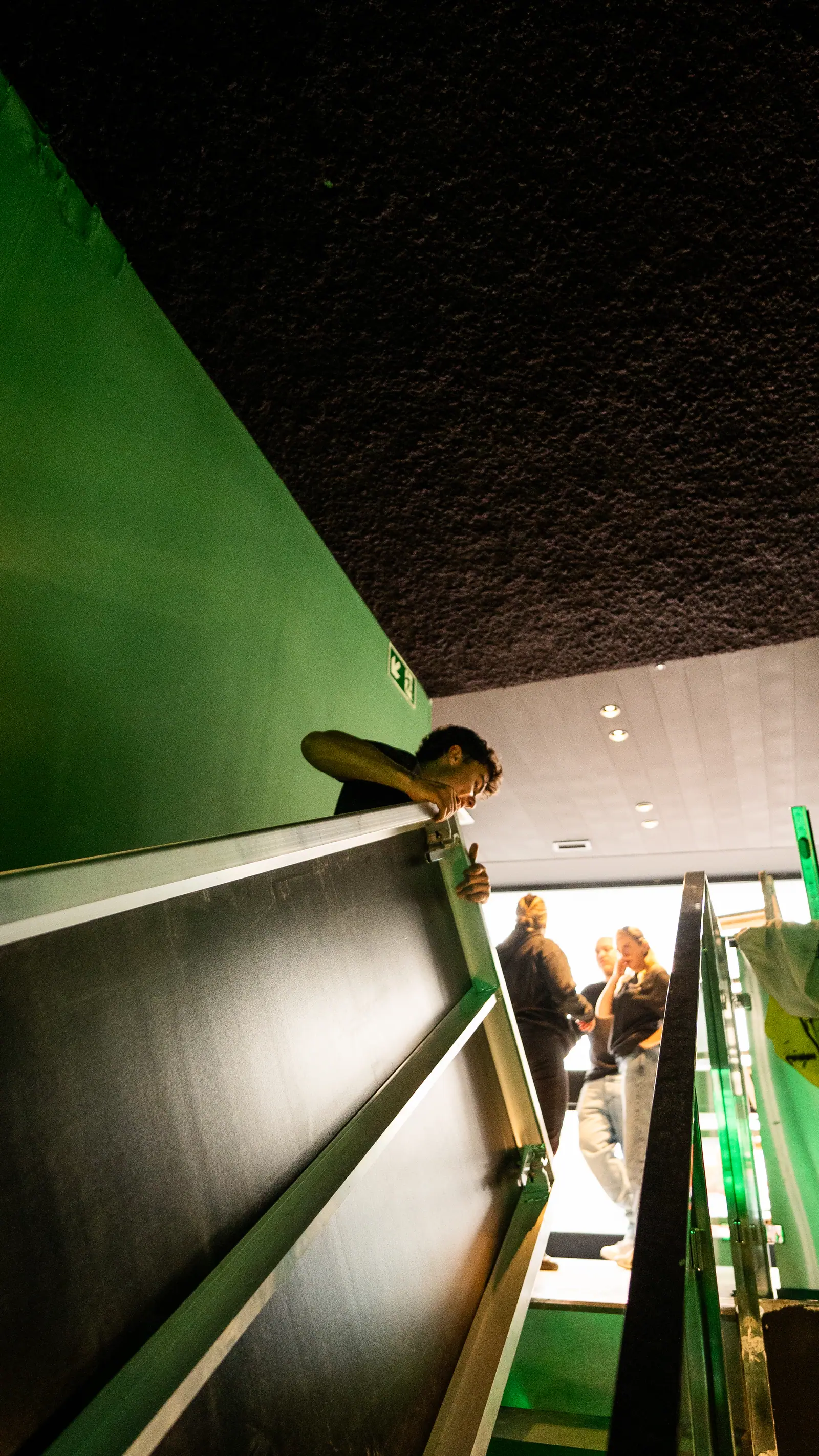Estructura metálica verde de escena con iluminación ambiente y neon integrado