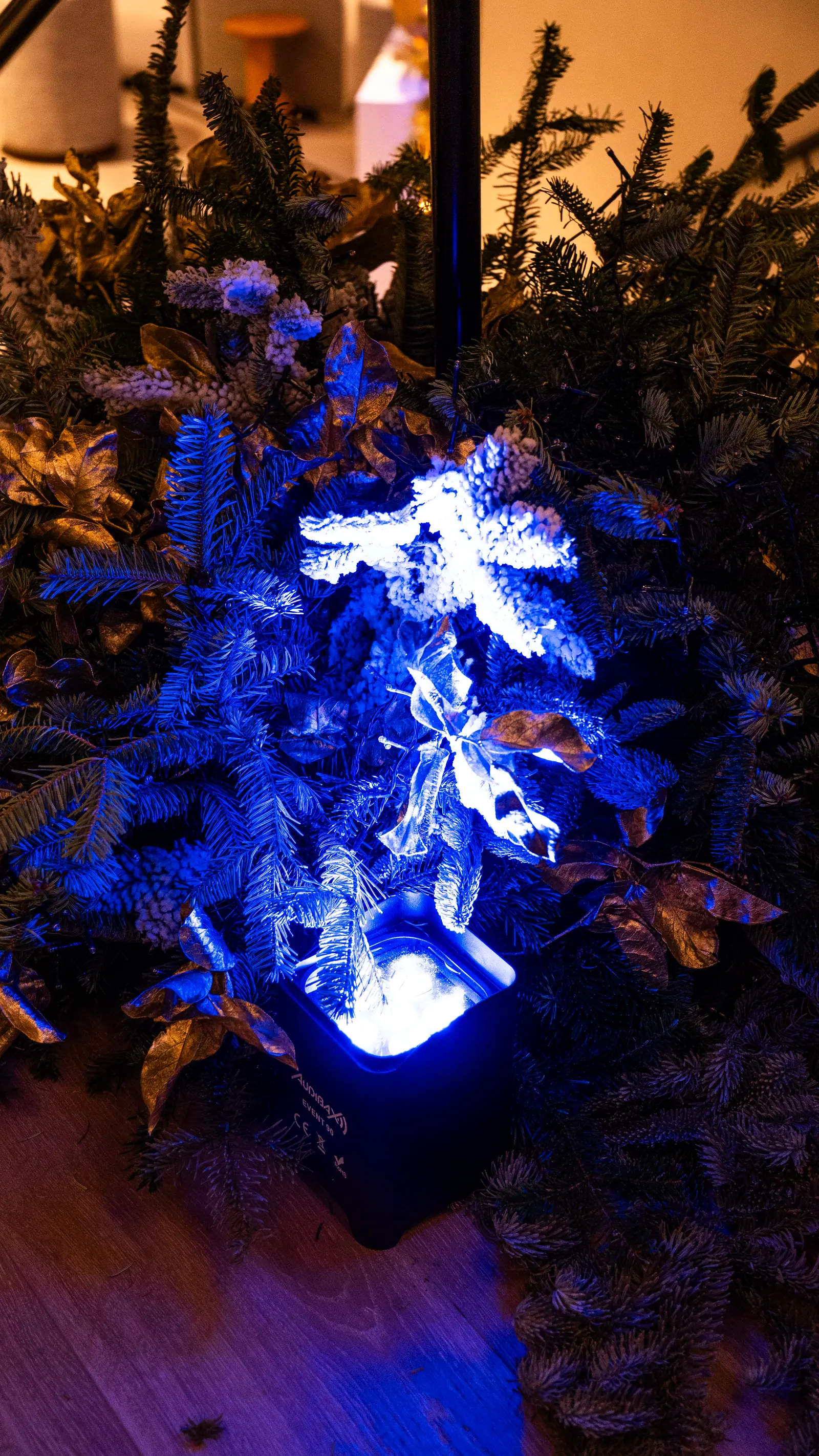 Detalle floral en naranja y azul iluminado en un evento corporativo